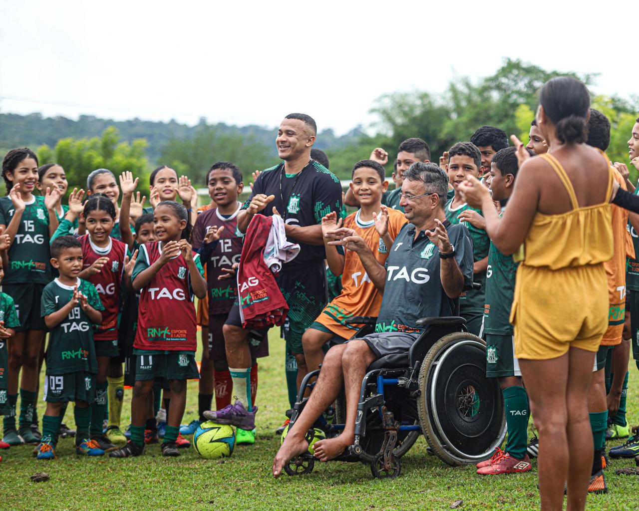 Crianças da escolinha de futebol da Associação Desportiva Bom Sucesso com treinadores em campo